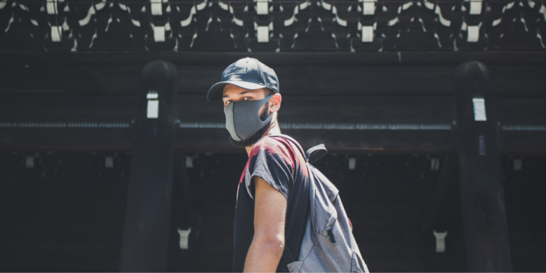 Photo of a man wear a face mask and carrying a backpack
