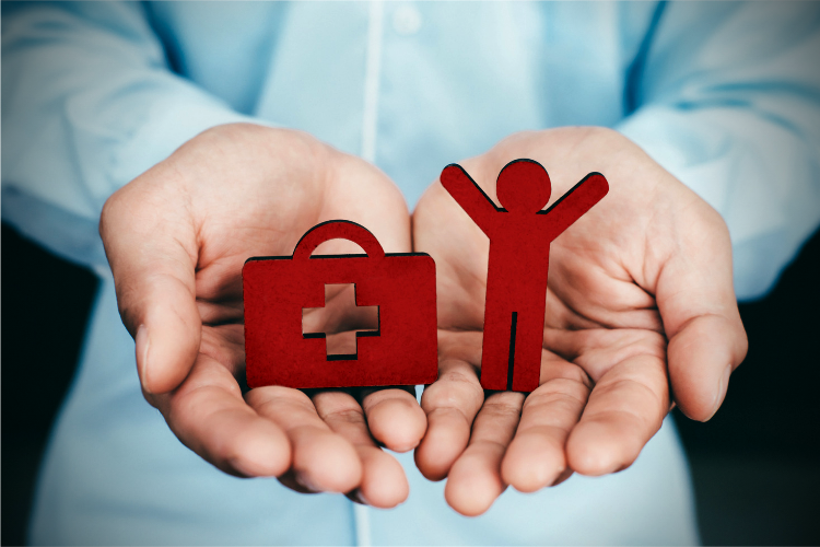 a woman holding wooden cutouts of a person and a medical briefcase