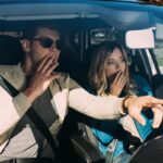 Driver glancing at phone behind the wheel, symbolizing the dangers of distracted driving