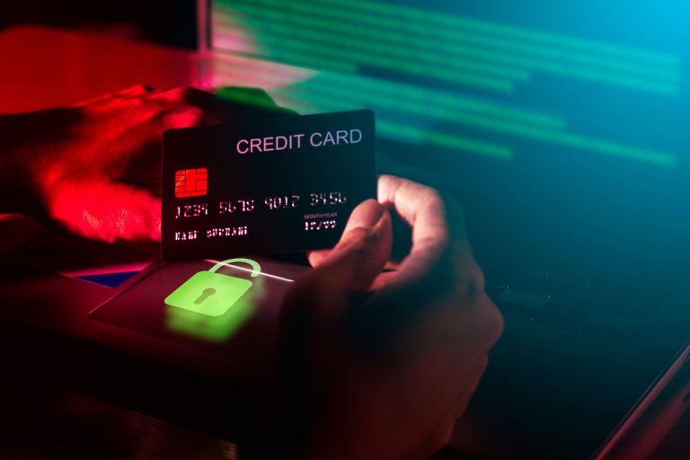 Dark image depicting a credit card and a laptop, symbolizing the risk of fraud and the need for cyber liability insurance coverage.